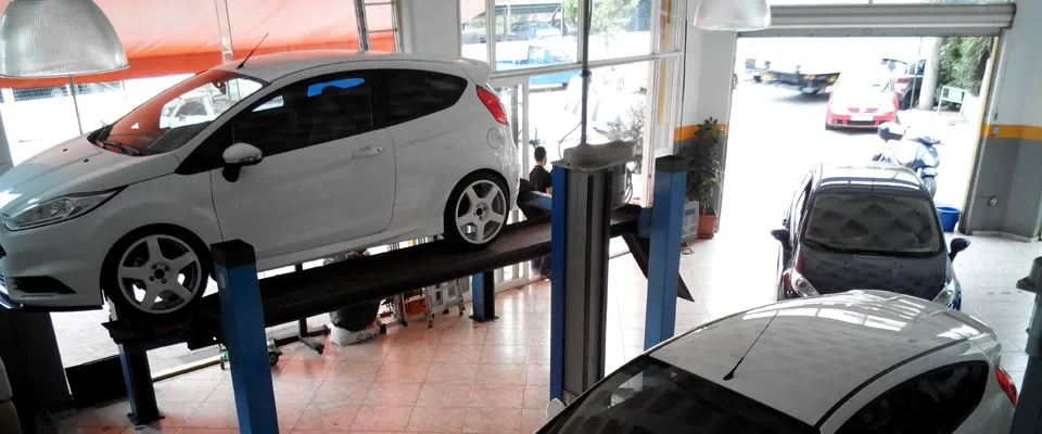 Λευκό Ford Fiesta στον ανυψωτήρα μέσα στο συνεργείο